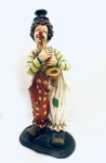 Escultura Palhaço musicista, confeccionada em resina de qualidade. Med. 70x33x21 cm.