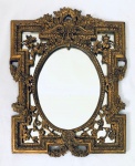 Espelho oval, com moldura retangular, com relevos em resina no tom dourado. Med. 42x32 cm.