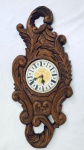 Relógio de parede em madeira entalhada, funcionamento à pilha, não testado, no estado. Med. 78x33 cm.