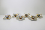 PORCELANA - Jogo de café em porcelana com farta douração e decorado ao centro com cenas galantes, composto de: 6 xícaras de café e seus respecitivos pires. Leves desgastes.