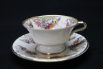COLECIONISMO - Linda xícara de chá em porcelana, decorada com rica policromia floral e filetes dourados. Med. 5,5x10,5 cm e 14,5 cm.