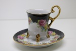COLECIONISMO - Delicada xícara de café em porcelana, decorada com rica policromia floral e filetes dourados. Med. 7x5 cm e 10 cm.