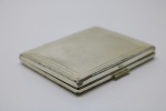PRATA DE LEI - Delicado porta pó de arroz em prata contrastada, teor 925 mls. Lavrada e cinzelada, espelho interno bisotado. Peso bruto 150 grs. Med. 7x8,5 cm. PEÇA NÃO EXPOSTA NO LEILÃO, A MESMA ENCONTRA-SE NO COFRE DO BANCO.