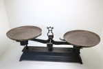 DIVERSOS - Antiga balança em ferro fundido, pratos de metal. Med. 3x57x30 cm.