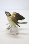 PORCELANA - Grupo escultórico em porcelana marcada no fundo (não identificada), vitrificada, policromada, representando passarinho. Med. 11x12x9 cm. bicado.