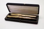 COLECIONISMO - PARKER 51 - Conjunto de 2 canetas, americanas, sendo 1 tinteiro e 1 esferográfica, ambas em ouro 18k, reserva gravada 'N H BIOLCHINI'.
