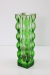 CRISTAL - Vaso floreira em em bloco de cristal em tom verde com lapidações onduladas. Marca de colado na borda. Med. 20,5x6x6 cm. Apresenta bicados.