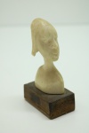 MARFIM - Estátua representando busto feminino, base em madeira. Med. 9x5x3 cm.