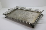 METAL - Bandeja retanfular em metal espessurado a prata, levrada com galeria vazada e elevada com pés em garra. Med. 5,5x48x28 cm.