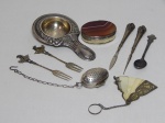 Nove peças diversas em metal: coador, infusor de chá, 2 garfinhos, colherzinha da Rolex, caixa aplicada com pedra e leque miniatura.