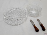 Lote composto de bowl em vidro moldado, pequeno prato de doce em vidro moldado e 2 espátulas de pasta com pega em madeira. Medindo o prato de doce 20cm de diâmetro.