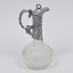 Claret jug  em cristal com guarnição em pewter decorado por figuras de parreiras em relevo, Europa, século XIX. Obs: Possui marcas do tempo em seu interior. Medida:30 cm x 16 cm