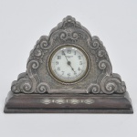 Relógio de mesa de manufatura  NEW HAVEN com aplique em prata decorado por concha e volutas e caixa em madeira nobre. Funcionando. Medida: 18 cm x 13 cm x 5 cm