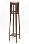 Linda coluna para floreira em madeira nobre entalhada, com acabamentos curvilíneos, possui platô inferior, apoiada sobre quatro pés. Medida: 106 cm x 27 cm