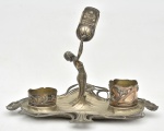 WMF - WMF(WURTTEMBERGISCHE METALLWAREN FABRIK) - Alemanha, c.1900 - Fosforeira em metal expessurado à prata, necessita solda nos braços, possui a peça. Possui marcas do tempo. Peça contrastada. Medida: 36cm x 22,5cm x 17cm de altura Tabaqueira/porta fumo; Medida: 7cm de diametro x 6cm de alturaTabaqueira/porta fumo; Medida: 7cm de diametro x 4cm de alturaFosforeira; Medida: 9cm de altura