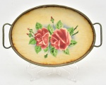 Bandeja de coleção em faiança alemã decorada com flores na galeria central, com cercadura em metal vazado. Possui marcas do tempo. Peça marcada Germany  e numerada na base. Med.:  29,5 cm x 18,5 cm x 3,5 cm; Vendida no estado.