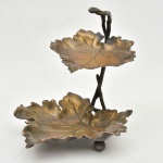WMF (WMF(WURTTEMBERGISCHE METALLWAREN FABRIK) Alemanha, circa de 1900. Fruteira/uveira de dois estágios em formato de folha em metal alemão. Medida: 20 cm x 18 cm x 18 cm.