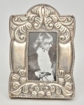 Porta retrato de prata de lei com decoração em relevo floral e fundo em madeira nobre. Medida: 18.5 cm x 13 cm