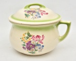MAUA - Urinol em faiança esmaltada pintado à mão em tom verde e policromia floral, marca de sua manufatura em sua base " trenzinho", década de 1940. Medida: 26 cm x 19 cm; NOTA: Abundância de argila e mão de obra de baixo custo transformaram Mauá, na região metropolitana de São Paulo, na capital da porcelana até meados do século 20. A cidade foi a primeira no Brasil a possuir uma fábrica de louça fina. No auge da produção, entre os anos 50 e 70, chegou a ter em torno de 20 fábricas abertas. A história da cidade com os pratos, xícaras e pires começou em meados de 1914, quando a primeira indústria do ramo chegou à região. A Fábrica de Louças Viúva Grande e Filhos, ou apenas Grande. Dois anos depois, um grupo de imigrantes italianos que trabalhava na Grande decidiu abrir uma fábrica própria, a Paulista, próxima ao rio Tamanduateí. A região contava com argila de qualidade e os terrenos eram baratos. Além disso, havia abundância de água e mão de obra. Atrás do sucesso das pioneiras, entre os anos 1920 e 1940 chegaram à cidade a Fábrica Nacional de Artefatos de Porcelana Brasilusa, a Santa Helena, a Cerqueira Leite, a Porcelana Mauá e a Porcelana Real, que mais tarde foi adquirida pela Porcelana Schmidt, uma das mais conhecidas marcas de louças finas brasileiras. A Schmidt chegou em 1948 à cidade, três anos após sua fundação em Santa Cantarina, e no auge da produção ofereceu emprego para quase metade da população local. Foi uma fábrica grande e importante. Nos anos 60, o vidro e o plástico tomam o espaço da porcelana nas mesas. Os padrões estéticos mudaram. O moderno era usar vidro e plástico, que começaram a substituir a louça. As fábricas resistiram até os anos 1970, mas sucumbiram à perda da mão de obra para a então crescente indústria automobilística na região do ABC paulista.