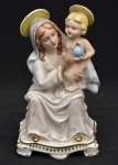 Grupo escultórico representando Nossa Senhora e menino Jesus em rica policromia, pintado à mão, com realces dourados. Peça numerada. Medida: 20 cm x 10 cm