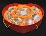 Conjunto de 6 xícaras com pires para café em porcelana esmaltada com decoração  policromada galante e carruagem. Estojo em formato de coração. Uma xícara possui uma alça quebrada. Medida pirex: 13cm Medida xicara: 6cm x 5cm de altura