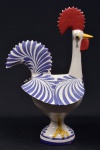 Galo de Barcellos em faiança policromada pintado à mão. Fio de cabelo que não altera o uso da peça. Medida: 38 cm altura x 18 cm altura x 23 cm comprimento.