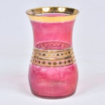 Antigo vaso em vidro pintado em tom rubi e decoração à ouro em relevo em seu bojo e decorado em sua borda por friso dourado. Desgastes na pintura. Medida: 17 cm x 10 cm