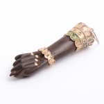 Figa em jacarandá com apliques em prata ricamente trabalhados, usada como pingente, em excelente estado, peça de coleção. Unhas encrustada em prata. Brasil, século XX. Medida: 6 cm x 1,8 cm