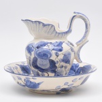 NARA - Gomil composto por jarra e bacia em faiança esmaltada nas cores azul e branco com pintura feita à mão floral. Jarra: 23 cm x 22 cm; Bacia: 30 cm de diâmetro x 7 cm de altura