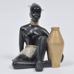 Escultura africana em porcelana esmaltada da década de 1960 em tom preto e dourado. Peça de coleção. Medida:  23 cm x 18 cm