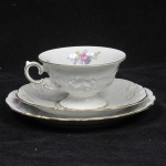 KPM - Trio composto de xícara de chá com pires e prato de bolo em porcelana esmaltada polonesa com decoração em rica policromia floral. Bordas douradas.  Peça de coleção.Marcado em sua base. Medida xícara: 10 cm x 6 cm; pires: 15 cm de diâmetro; Prato: 17 cm de diâmetro