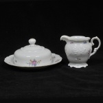 KPM -  Lote composto de leiteira e manteigueira em porcelana esmaltada polonesa com decoração em rica policromia floral. Bordas douradas.  Marcado em sua base. Medida:*