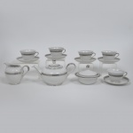 MAUA - Aparelho de chá em porcelana branco com frisos prateados com marca de sua manufatura em sua base composto de 5 xícaras de chá com pires, bule, leiteira e manteigueira. Art deco. Medida: Xicara - 9cm x 6cm de alturaPirex:13,5cmBule: 23cm x 14cm x 14cm de alturaLeiteira: 15cm x 10cm x 11cm de alturaMantegueira: 14cm x 5cm x 11cm de altura