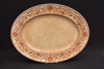 Travessa oval grande  em seu padrão chamado DORSET feita em Stoke, Staffordshire, Inglaterra, na década de 1930. Este padrão em tom marrom e cor de marfim em porcelana tem rosas rubi e guirlandas  policromadas, grinaldas com folhas e volutas marrons e flores verde-limão conectam o padrão. Uma pequena faixa marrom floral e quadrada na borda e outra faixa interna de figuras geométricas perto da borda. Esta é em porcelana e é um item muito substancial, bem feito. Está em muito bom estado. Marca de sua manufatura em sua base. Medida: 36 cm comprimento x 28 cm largura.