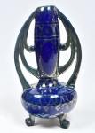Vaso em faiança esmaltada europeu com siglas em sua base " "JBH" com pintura prateada fundo azul cobalto apoiado sobre três pés ligeiramente curvos início do século XX. Medida: 39 cm x 22 cm x 22 cm