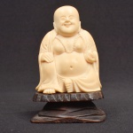 Escultura representando Buda da fartura em marfim com base em madeira (9 cm x 6 cm x 4 cm)