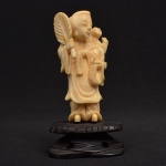 Escultura em marfim oriental representando de gueixa com criança nas costas com base em madeira. Medida: 10 cm x 5 cm x 4 cm