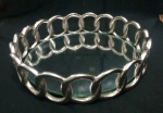 Bandeja redonda espelhada,  em elos na cor prata,  - Diâmetro:  22 cm - Espelho com mancha.