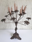 Candelabro para oito velas em bronze, base representado menino e com folhas e pombas. MED: 54CM ALT.