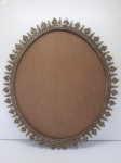Moldura oval em bronze com borda recortada com flores. Med.: 47 x 57 cm e med. interna 45 x 39cm