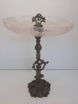 Fruteira com base em bronze, representando menino, prato em antigo vidro moldado rosa. Trincado. MED.:45cm alt e 28cm diâmetro.