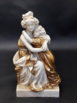 Bela escultura representando mãe e filha em porcelana branca e com linda pintura dourada. MED.: 12x7cm
