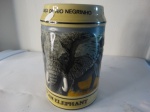 Caneco representando elefantes em porcelana com desenhos em alto relevo. Altura: 15cm.