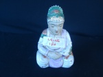 Buda em porcelana com policromias. Altura: 16 cm.
