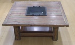 Mesa de centro construída com madeira de demolição, tendo ao centro floreira em ferro forjado e patinado com alças, altuta 41 x 100 x 100 cm.