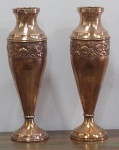 Par de vasos em cobre decorados com motivos florais em relevo, com marca do fabricante na base, veja foto anexa. Altura 50 cm e diâmetro da boca 10 cm. Um deles apresenta sinais de solda na junção com a base.
