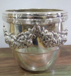 Lindo cachepot em metal prateado com motivos florais em relevo, altura 20 cm e diâmetro da boca 20 cm.