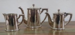 Conjunto para café e chá em metal espessurado a prata sendo: bule  de chá com 19 cm de altura, 1 leiteira com 9 cm de altura e 1 bule de café com 14 cm de altura. Tampa do bule de café necessita restauro, está solta.