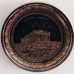 Prato em  porcelana Grega ricamente decorado em ouro 24K retratando o Acrópolis  Parthenon. Mede: 19 cm.