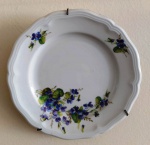 Prato em  porcelana alemã ornamentada com com flores azuis arroxedas.Marca: BAVÁRIA. Possui suporte para parede . Mede: 19 cm.